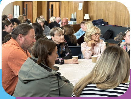 Groups of people sitting at round tables working together